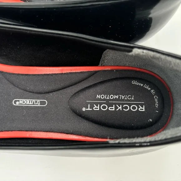 M302 Rockport total motion Women’s flats of black patten. Has cushioned insole.
