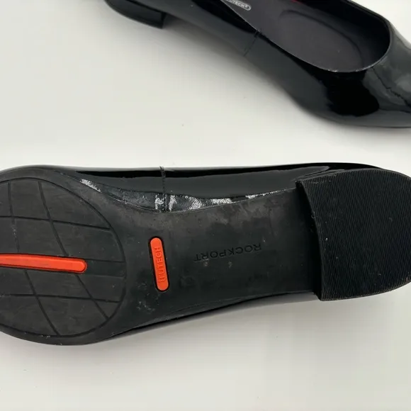 M302 Rockport total motion Women’s flats of black patten. Has cushioned insole.