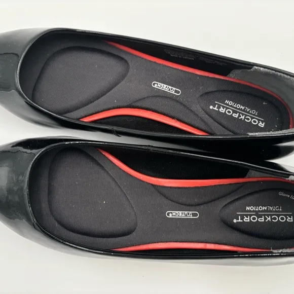 M302 Rockport total motion Women’s flats of black patten. Has cushioned insole.
