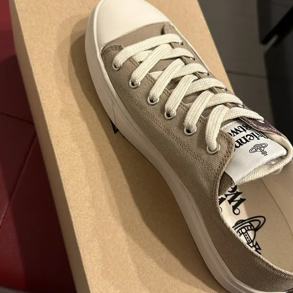 Vivienne Westwood designer sneakers are size 7. Beige with a purple design.